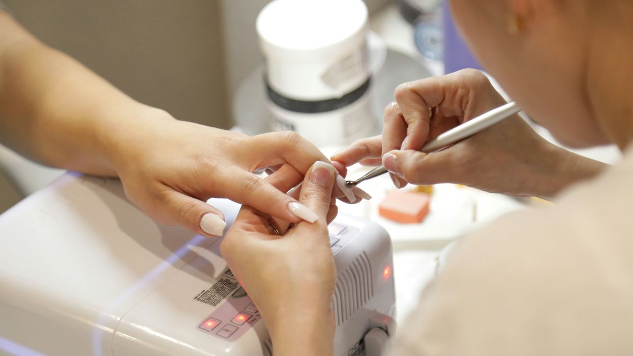 hands of a woman getting her nails done at a nail salon.