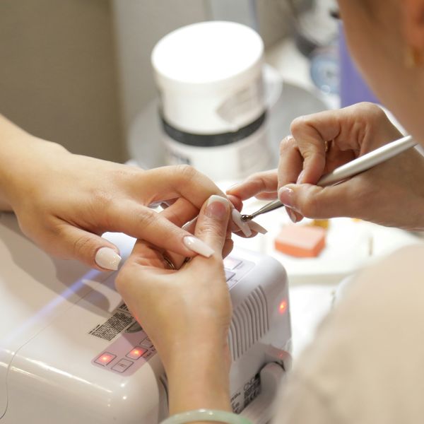 hands of a woman getting her nails done at a nail salon.