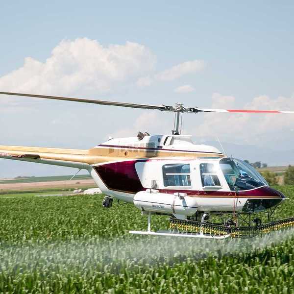 Helicopter as a crop duster in north central Colorado spraying a corn field.