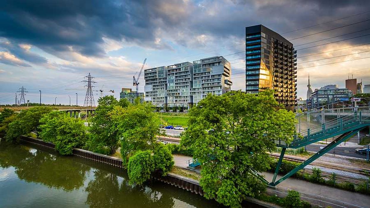 High rises, train tracks and electric towers alongside a river