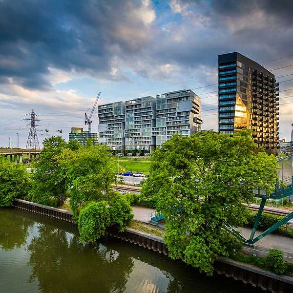 High rises, train tracks and electric towers alongside a river
