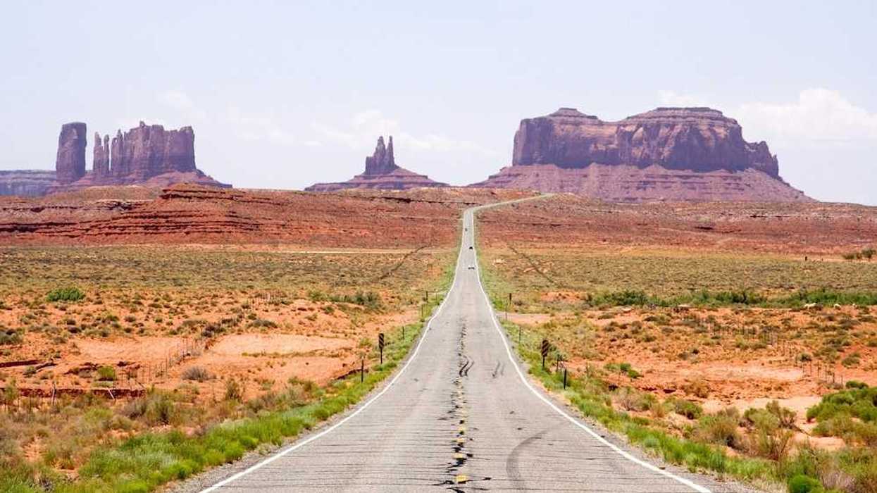 Highway in the American Southwest stretching towards distant mesas
