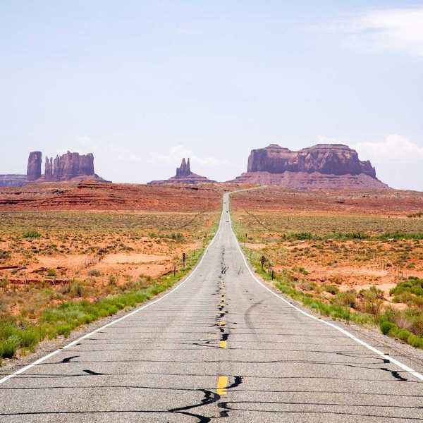 Highway in the American Southwest stretching towards distant mesas