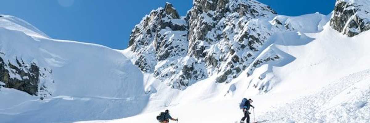 Hikers making their way up a snowy mountain.