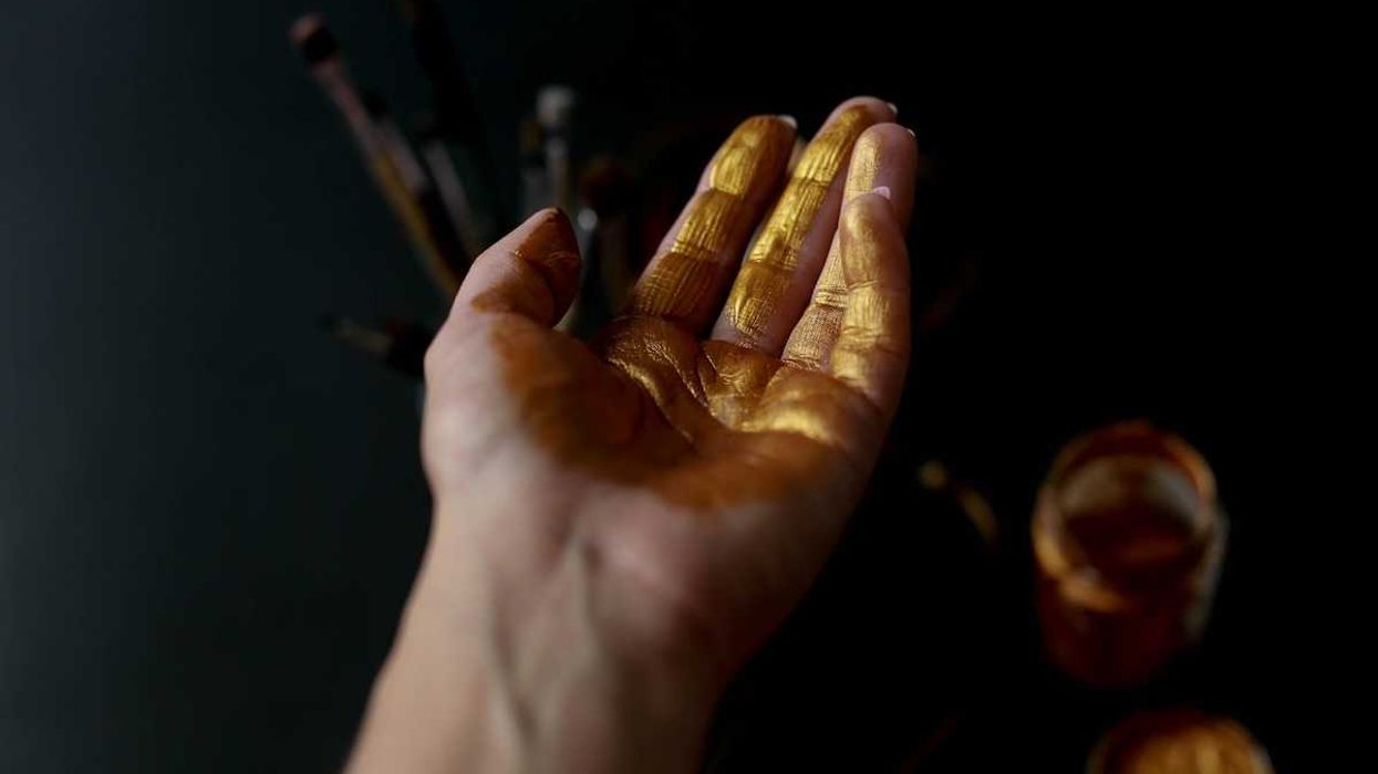 Human palm of hand coated with gold