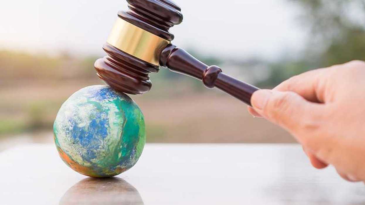 Illustration of judges gavel poised to strike planet model
