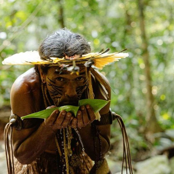 Indigenous Amazonian tribesman sipping water from a leaf
