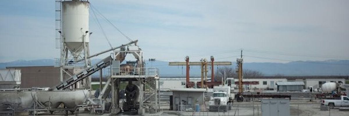 Industrial buildings and equipment on a cloudy day.