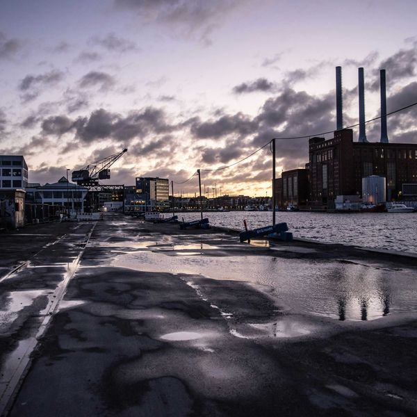 Industrial buildings next to the water at sunset