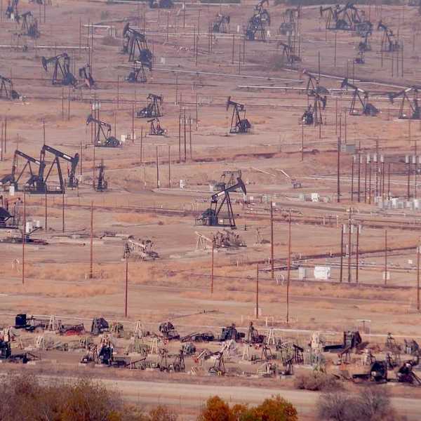 Industrial landscape, oil derricks in desert valley.