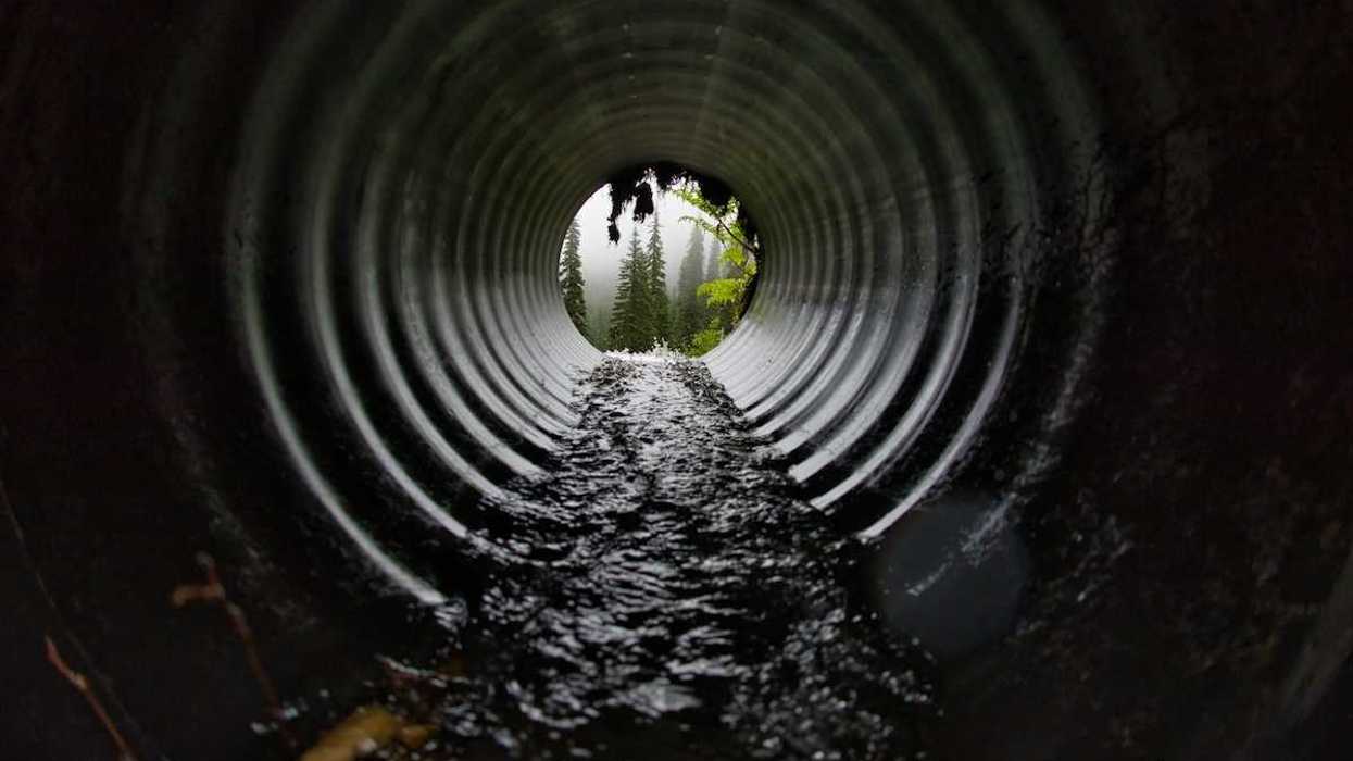 Interior of a wastewater pipe showing some accumulated sludge