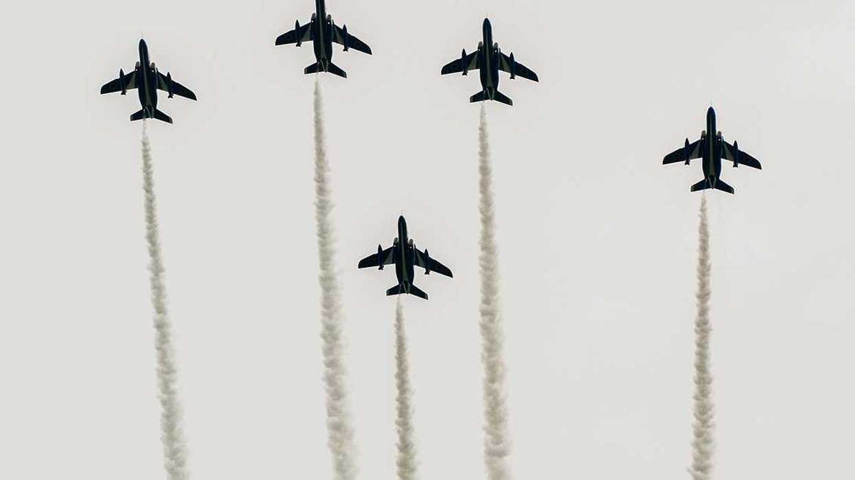 Japanese fighter jets perform maneuvers in flight formation for military drills.