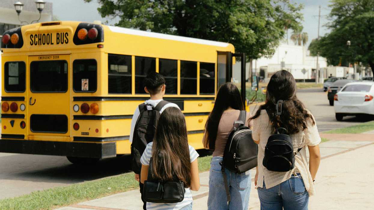 Kids walk to a school bus stop