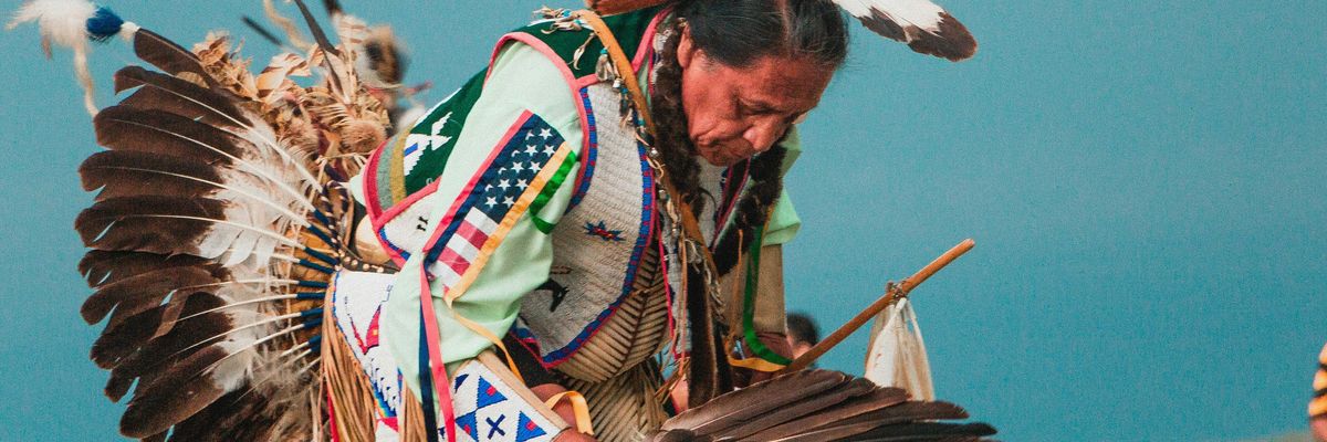 Lakota man wearing headdress at a powwow.