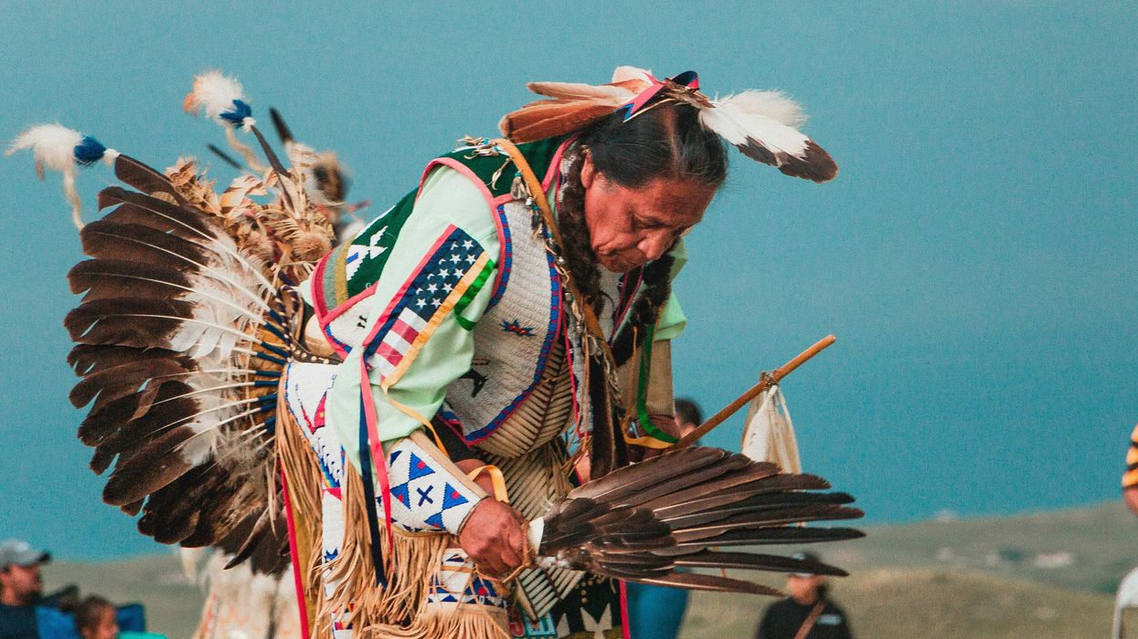 Lakota man wearing headdress at a powwow.