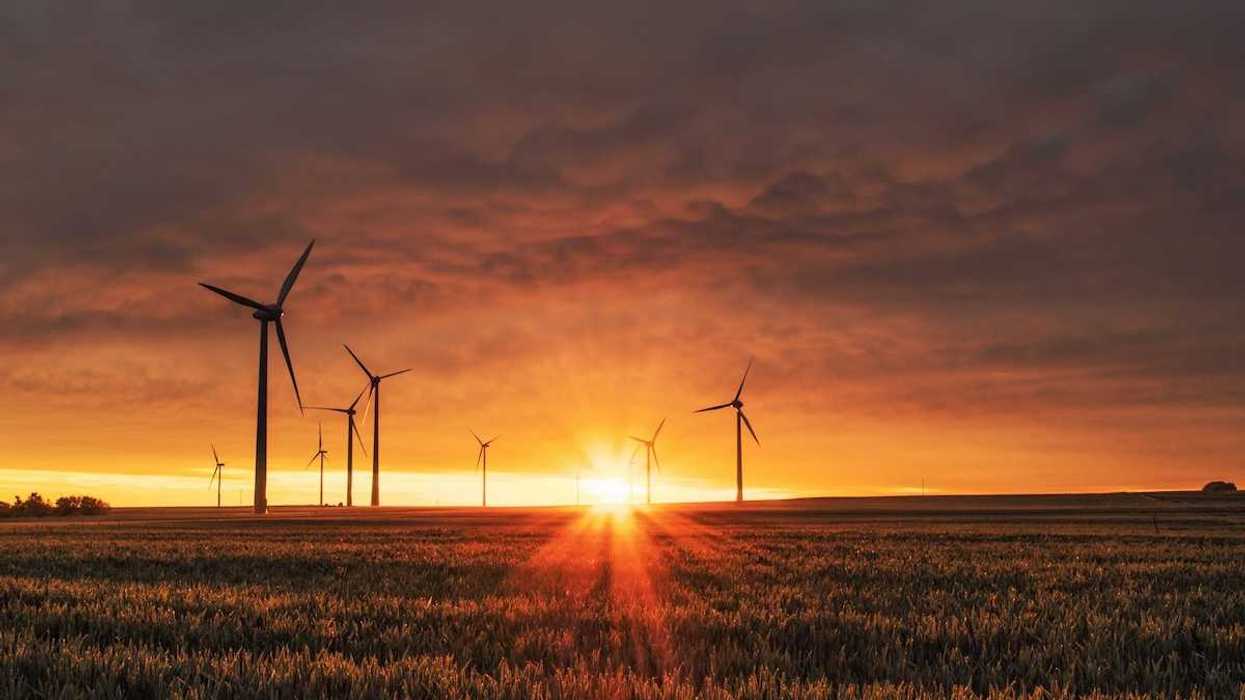 Land-based wind turbines against a rising sun
