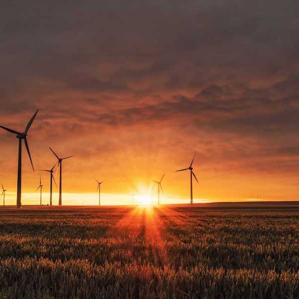 Land-based wind turbines against a rising sun