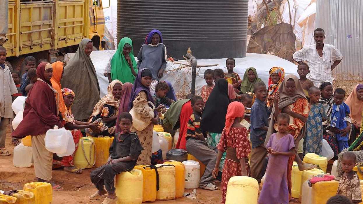 Large group of African people waiting to get water.