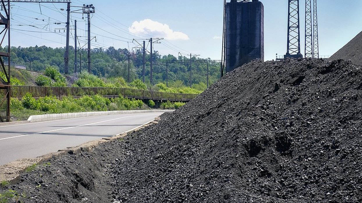 Large pile of coal with electric lines in the background