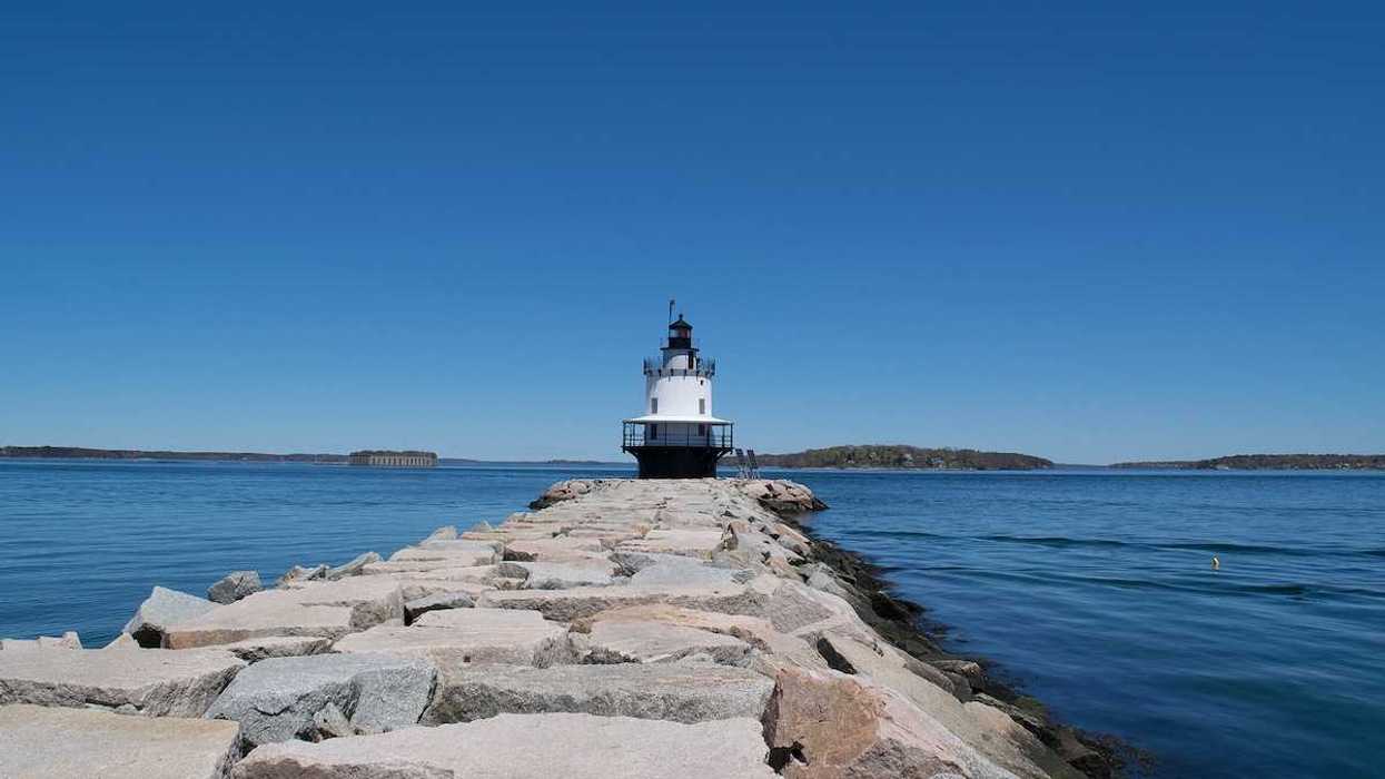 Lighthouse with a blue sky and sea wall