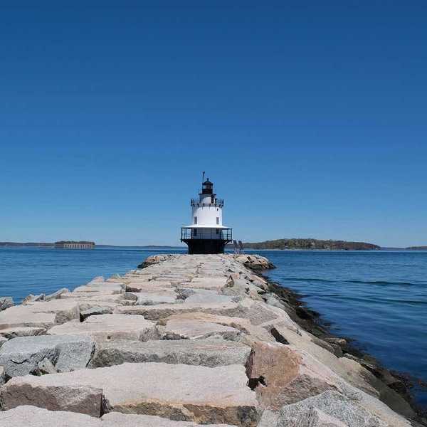 Lighthouse with a blue sky and sea wall