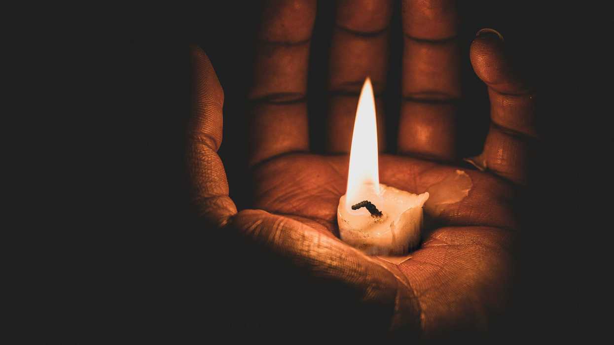 lit candle in hand.