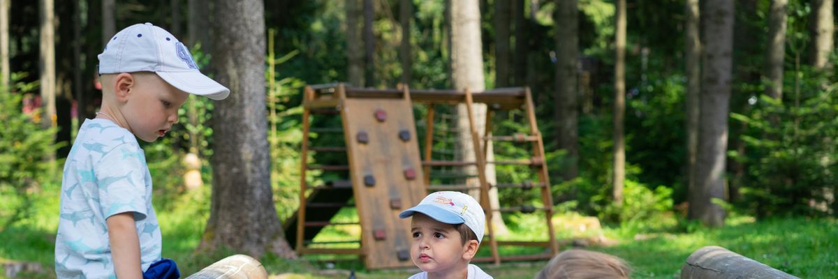 Little boys play with toy trucks in a sandbox