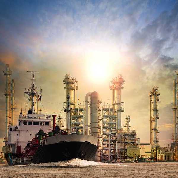 LNG tanker ship with oil & gas refinery plant in background