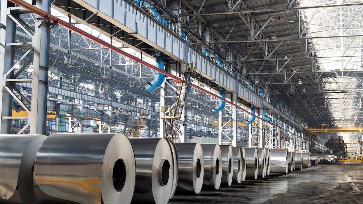 Long row of rolls of aluminum in production shop of plant.