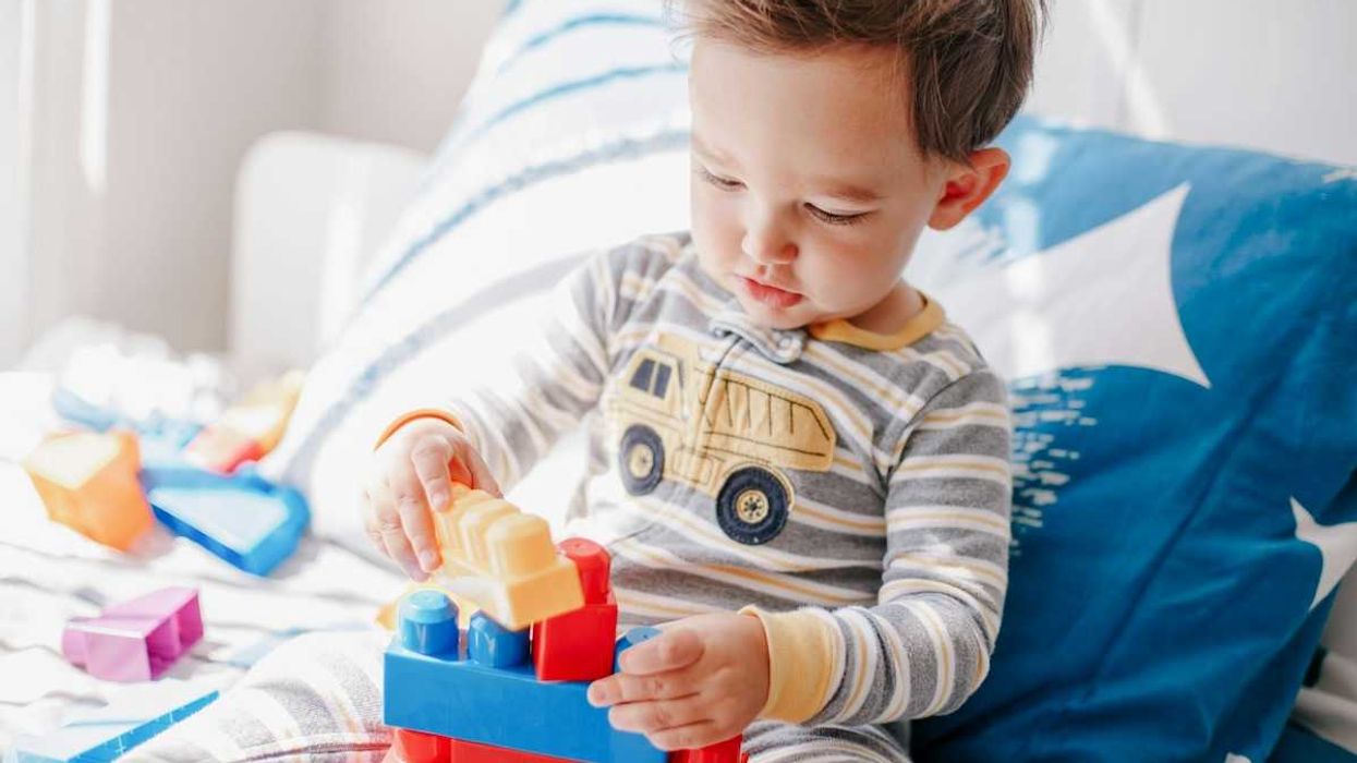 Male toddler playing with interlocking plastic blocks