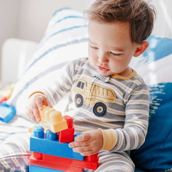 Male toddler playing with interlocking plastic blocks