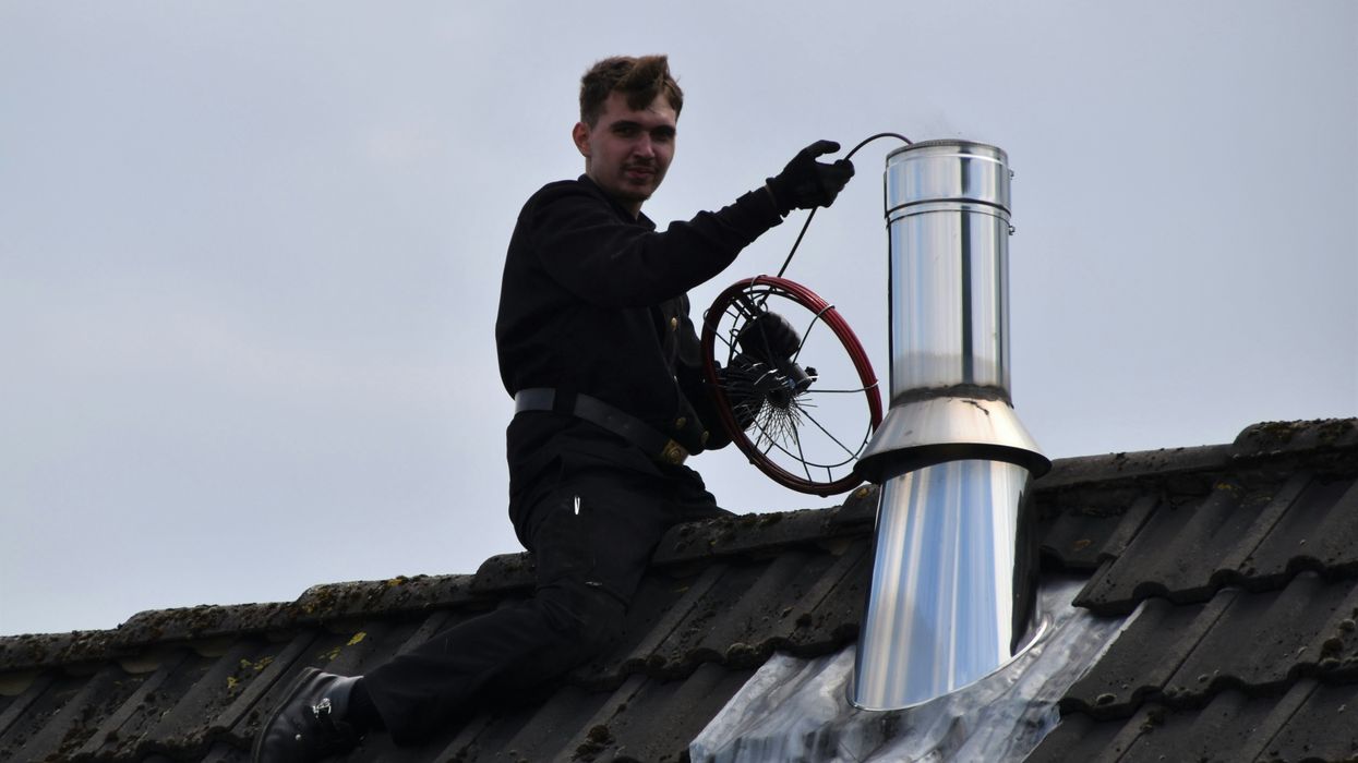 man in black jacket sitting on roof during daytime