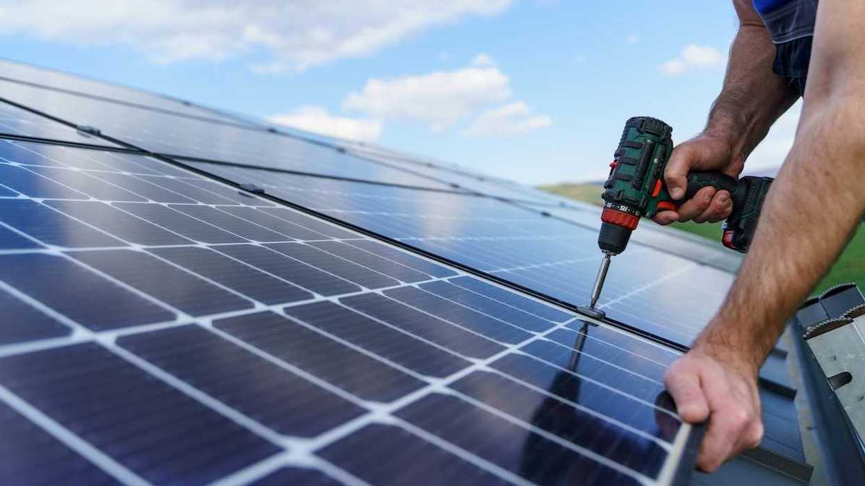 Man installing solar panels on a roof