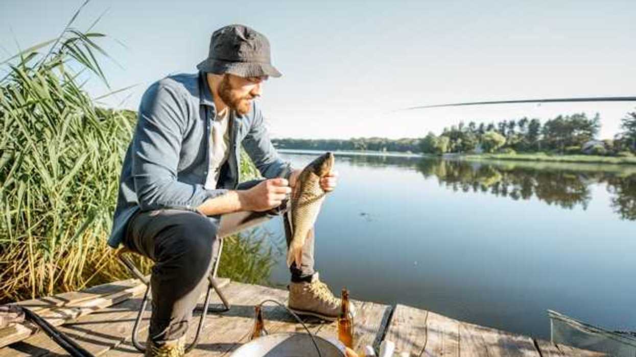 Man on a dock after having caught a fish
