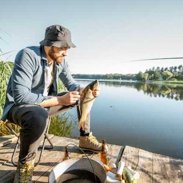 Man on a dock after having caught a fish
