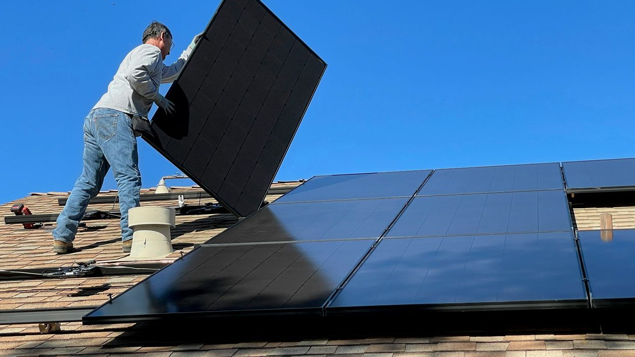 Man on roof installing rooftop solar.