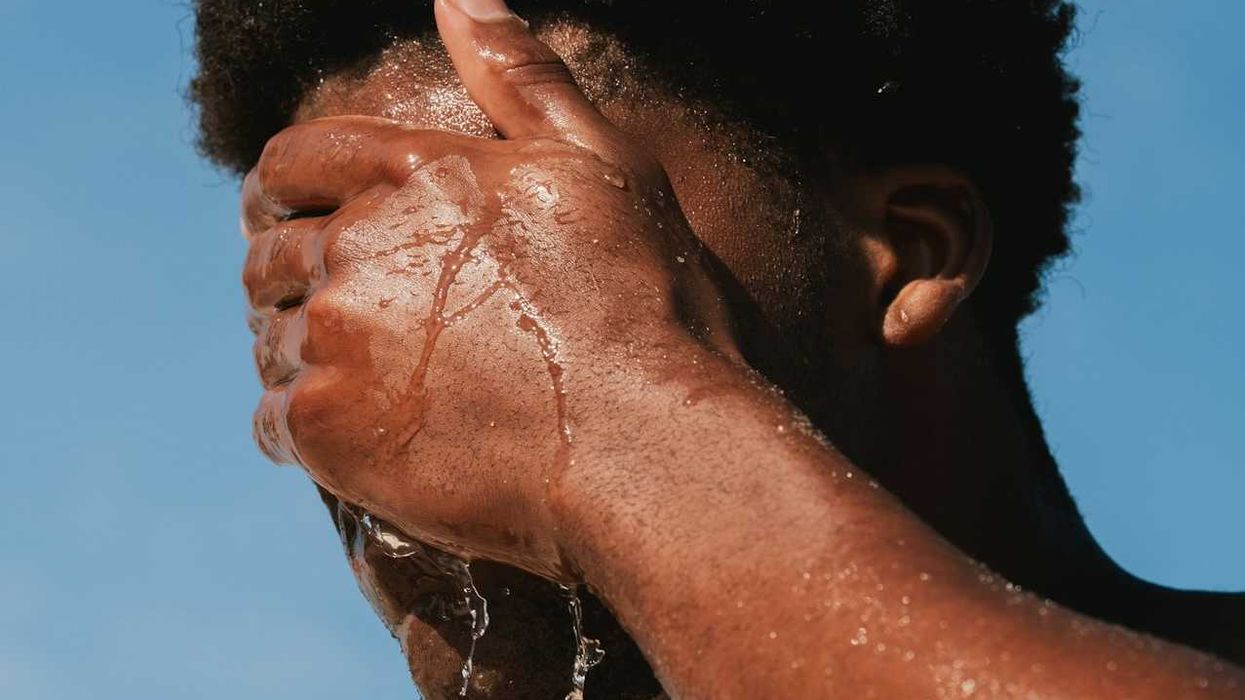 Man splashing water on face for heat relief