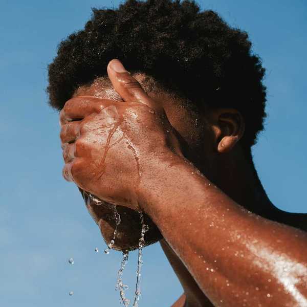 Man splashing water on face for heat relief