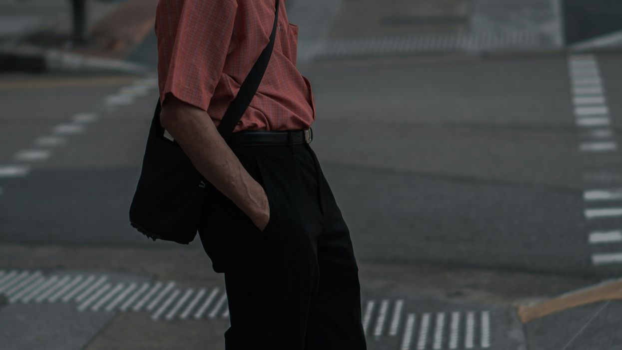 Man wearing a face mask crossing a street.