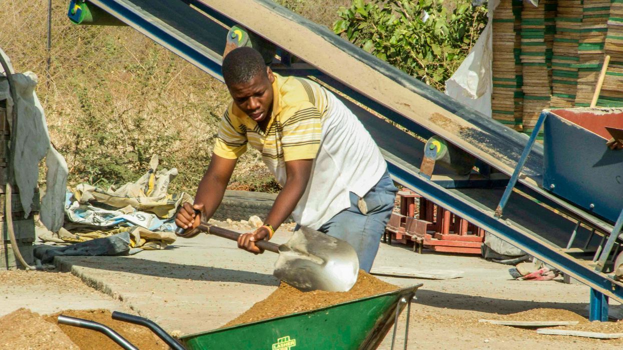 man working outside with wheelbarrow shovel