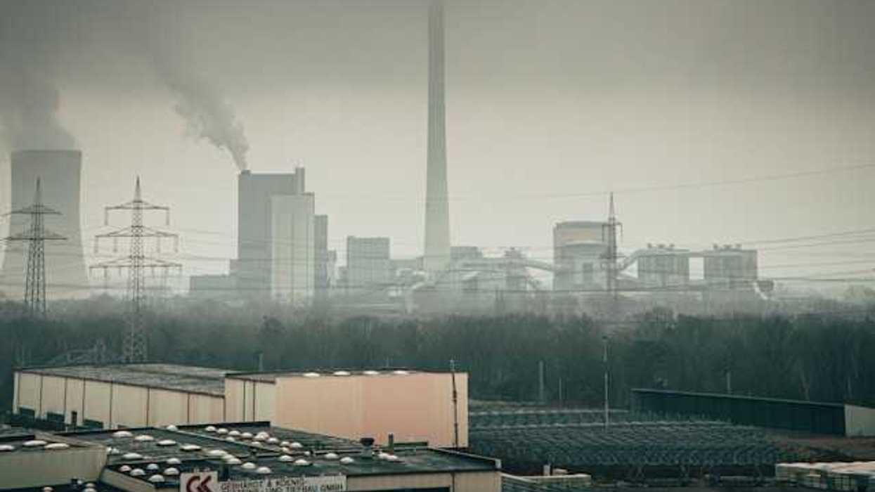 Manufacturing plant with smoke rising from towers