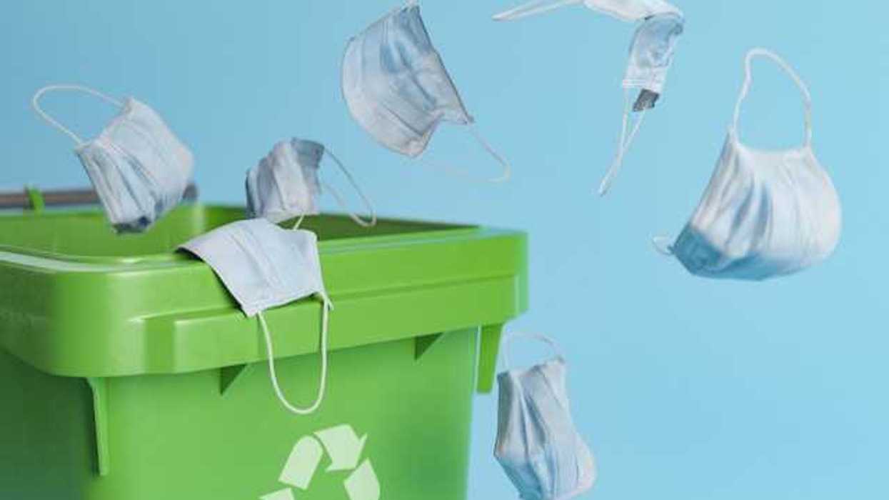 Medical face masks being thrown into a recycling bin