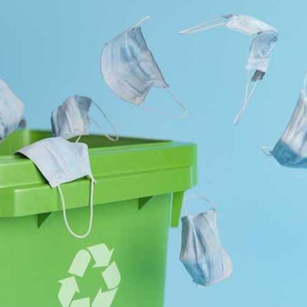 Medical face masks being thrown into a recycling bin