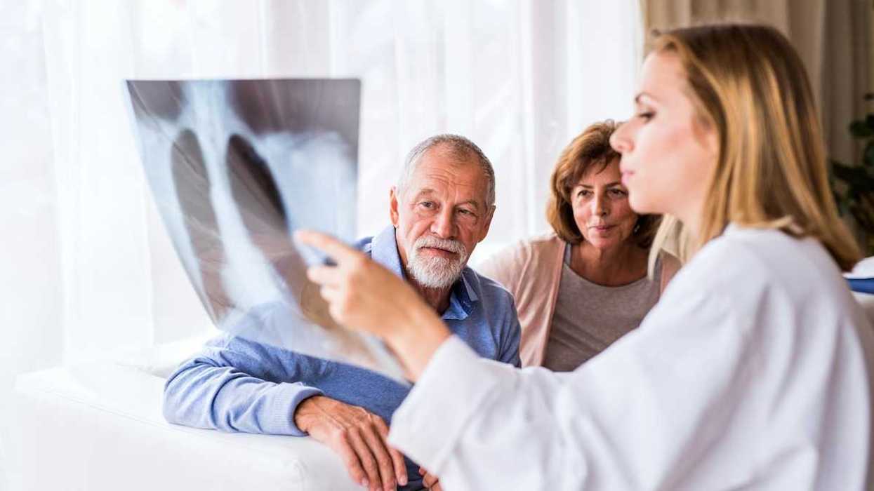 Medical professional with scan displaying and explaining imaging results to a man and woman