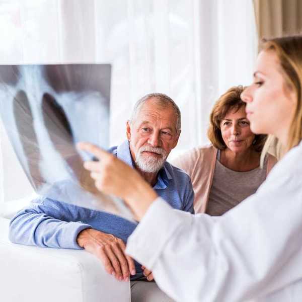 Medical professional with scan displaying and explaining imaging results to a man and woman