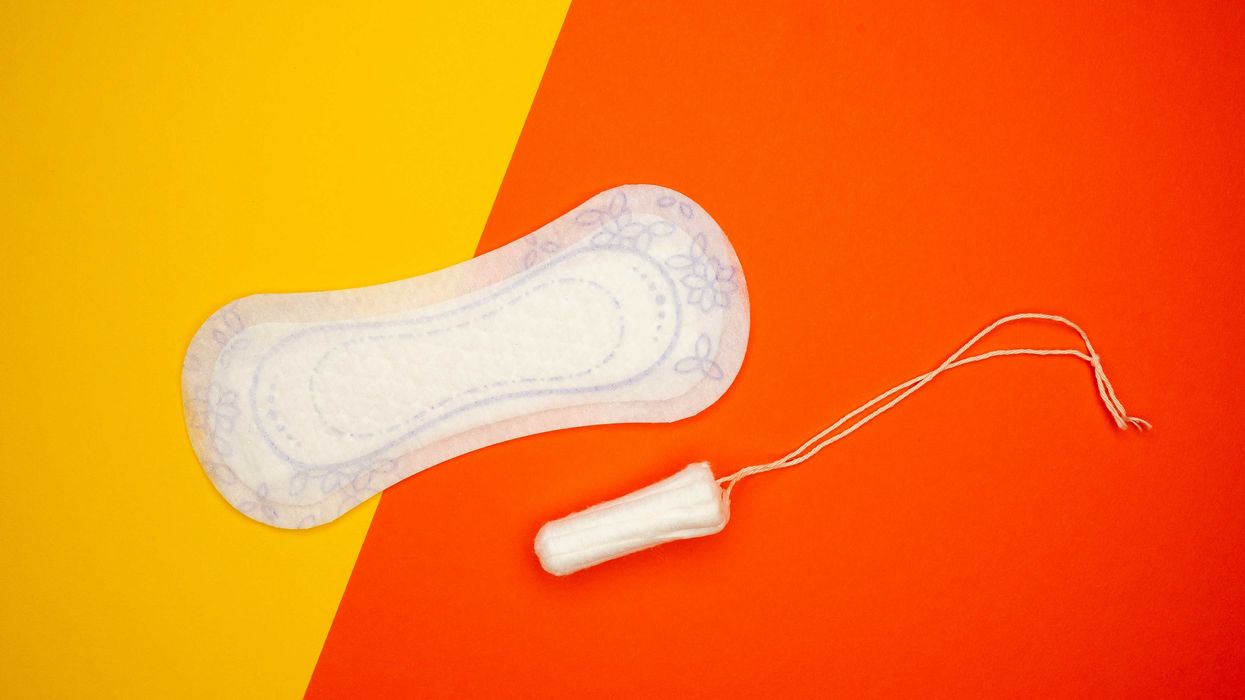 Menstrual pad and tampon against a yellow and orange background.