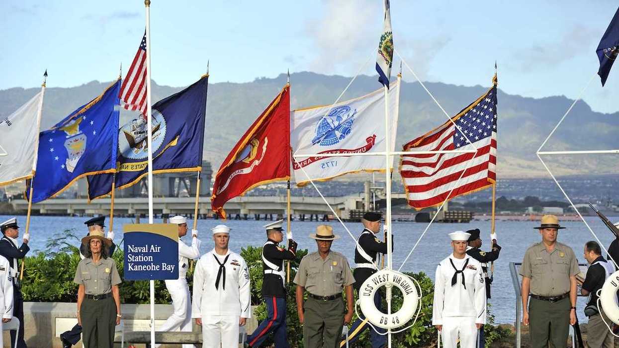Military and NPS personnel at Pearl Harbor ceremony, standing at attention with color guard carrying flags behind