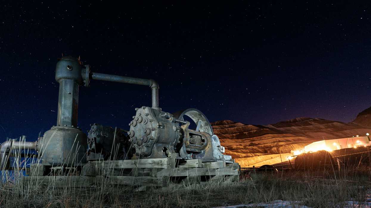 Mining operation and machinery illuminated at night.