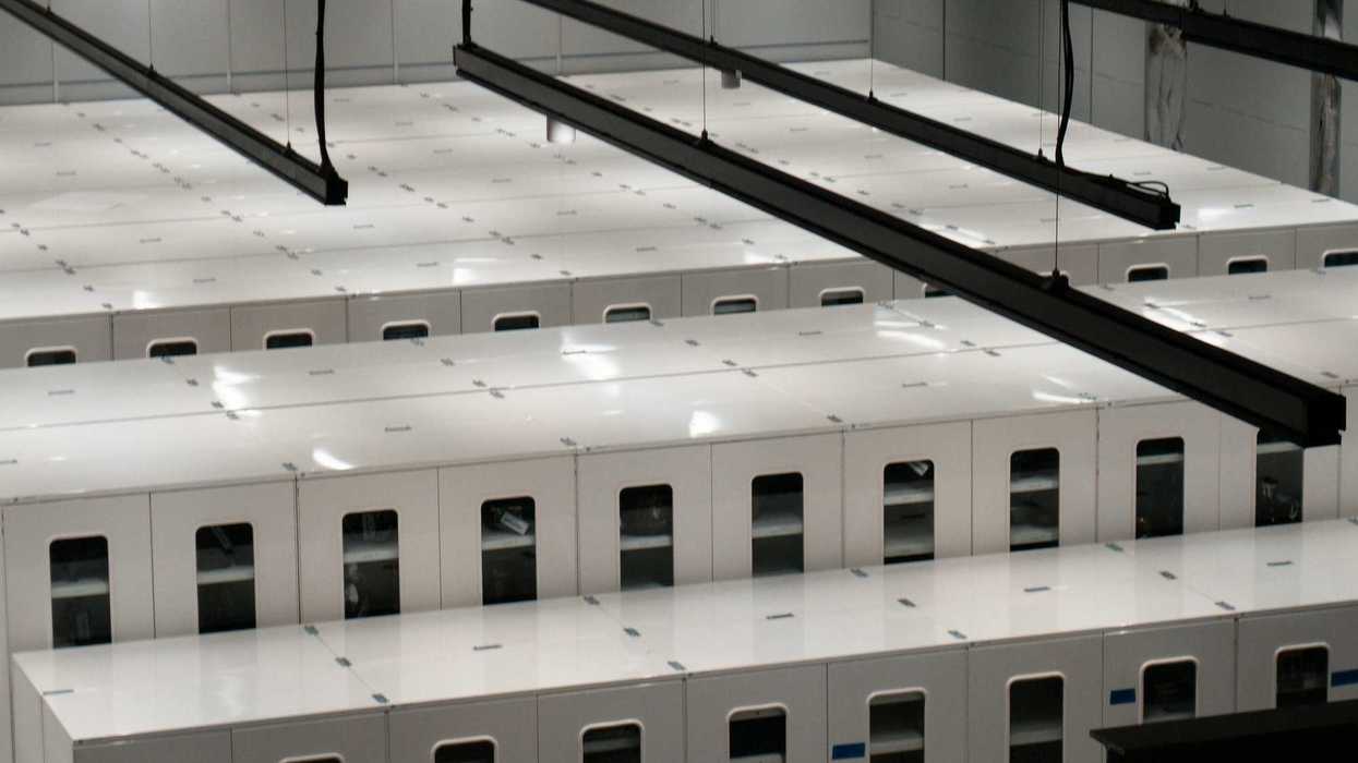 Modern data center with rows of white server cabinets.