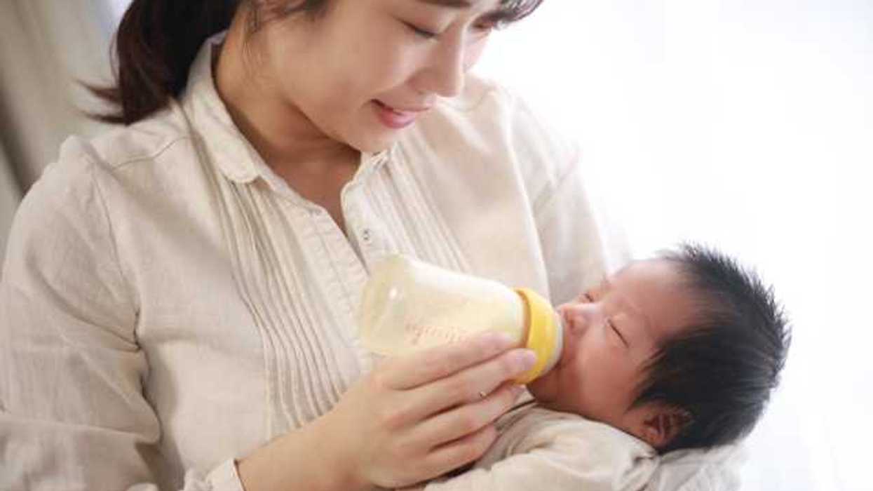 Mother holding baby feeding it a bottle